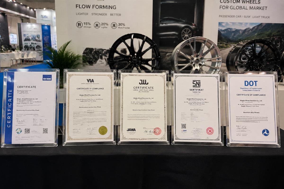 Wheel certification certificates displayed on a trade show booth table